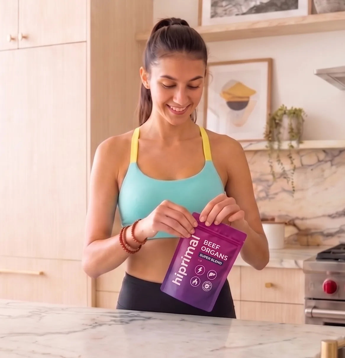 Woman opening a HiPrimal pouch in a bright kitchen